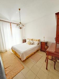 a white bedroom with a bed and a piano at Casa Verdi Telti in Telti