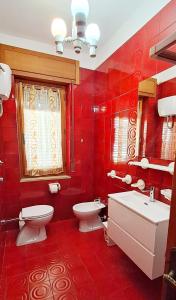 a red bathroom with a toilet and a sink at Casa Verdi Telti in Telti +12 photos