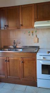 a kitchen with a sink and a stove at Casa Verdi Telti in Telti