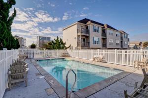 a swimming pool with chairs and a white fence at Hamlet Hideaway in Carolina Beach