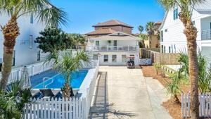 een wit huis met een zwembad en palmbomen bij The Beverly in Destin