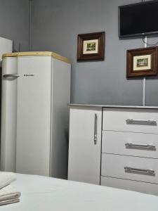 a kitchen with a refrigerator and a flat screen tv at Pousada Santo Agostinho in Extrema