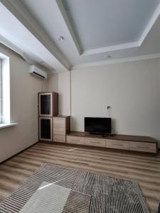 a living room with a flat screen tv in a room at Apartment in street Togolok Moldo 3 A in Bishkek