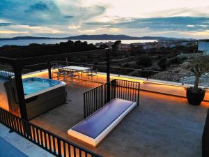 - Balcón con bañera de hidromasaje y mesa en Rooftop Holiday House, en Brodarica