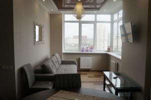 een woonkamer met een bank en een raam bij Apartment on Pozhyaki in Kiev