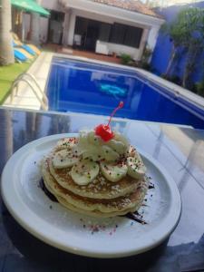 a plate with a stack of pancakes with a cherry on top at Hotel Casa ixtapan in Ixtapan de la Sal