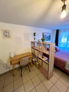 a bedroom with a bed and a desk and a table at Montbel'appart - Charmant appart T1 tout équipé in Montbéliard