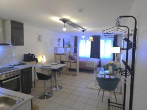 a kitchen and living room with a room with a bed at Montbel'appart - Charmant appart T1 tout équipé in Montbéliard