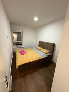 a bedroom with a bed with two pink pillows on it at I&I Tesla Apartments II in Kragujevac