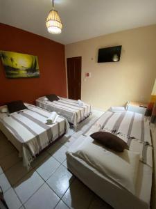 a room with two beds and a tv on the wall at Residencial Dragão in Fortaleza