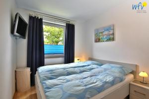 a bedroom with a bed and a window at Residenz am Alten Leuchtturm Ferienwohnung 7 in Wangerooge