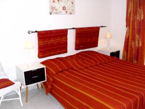 a bedroom with a bed with red sheets and red towels at Studio Des Iles in Saint-François