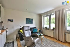 a living room with a couch and a chair at Residenz am Alten Leuchtturm Ferienwohnung 7 in Wangerooge