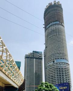 a tall building with a sign on the side of it at Uniqinn Studio Supernova in Noida