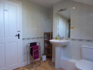 a bathroom with a sink and a toilet and a mirror at Orchard House Bed and Breakfast in Grassington