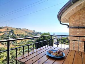 a plate of food on a wooden table on a balcony at Double Sea View Design Wi-Fi Parking AC in Fermo