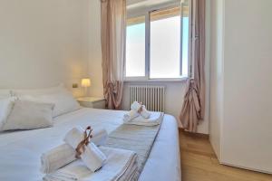 a bedroom with a bed with towels and a window at Double Sea View Design Wi-Fi Parking AC in Fermo