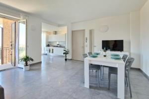 a white dining room with a white table and chairs at Double Sea View Design Wi-Fi Parking AC in Fermo
