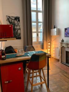 a room with a desk and a table with chairs at Centre historique, appartement cosy in Avignon