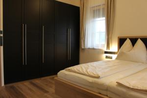 una camera da letto con letto e armadi neri di Nussberg Chalet a Ehrenhausen Altre 26 foto