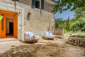 two chairs sitting in front of a building at Sa Rectoria d'Orient in Orient