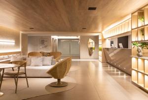 a living room with a couch and a table and chairs at Ritz Suites Grand Hotel Boutique in Maceió