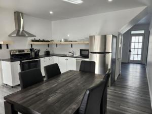 a kitchen with a wooden table and chairs in it at Auberge Le Cosy Amos in Amos