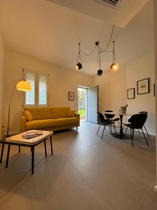 a living room with a yellow couch and a table at Il Giardino Segreto in Faggeto Lario 