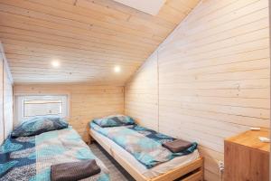 two beds in a room with wooden walls at Sielsko-Anielsko Kobyla Góra I in Ligota +17 photos