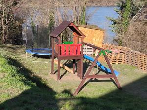a wooden playset with a playground in the grass at Nyugalom Kulcsa in Kulcs
