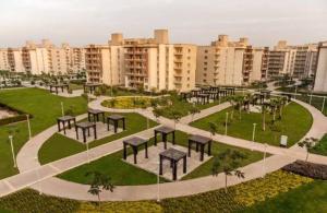 a park with tables and benches in a city at شقه إيجار wesal in Madīnat ash Shurūq