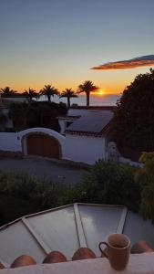 a cup of coffee sitting on a table with the sunset at Casa Lima Mediterránea in Benitachell