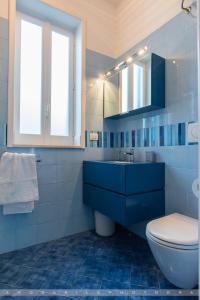 a blue bathroom with a toilet and a sink at Suite Giò in Savelletri di Fasano +7 photos