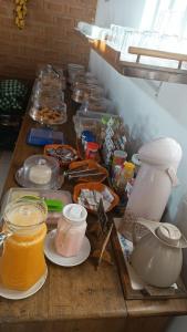 a table with many jars of food on it at Pousada Flor de Jambo in Ubatuba
