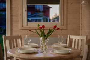 a table with a vase of red tulips on it at FHU Aquarius in Dziwnówek