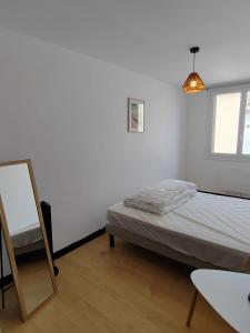 a white room with a bed and a mirror at Beau T3 coeur village in Gruissan