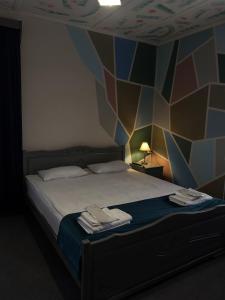 a bedroom with a bed with a geometric wall at Paxlava Dilijan Guesthouse & Restaurant in Dilijan