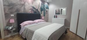 a bedroom with a bed with pink pillows and a painting at Sweet Home Caterina in Gradoli