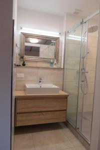 a bathroom with a sink and a glass shower at Ferienwohnung 2 am Zwenkauer See-frisch renoviert in Zwenkau