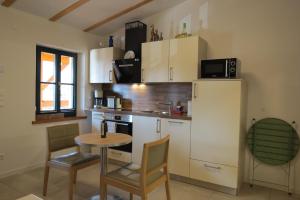 a kitchen with a small table and a refrigerator at Ferienwohnung 2 am Zwenkauer See-frisch renoviert in Zwenkau