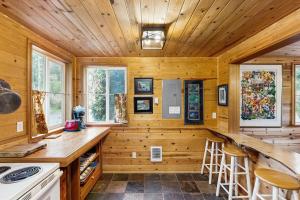 a log cabin kitchen with a counter and stools at Laura Mar Artist's Retreat in Otter Rock