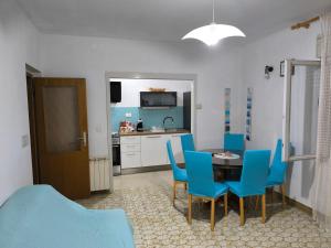 a kitchen and dining room with a table and blue chairs at Apartmani Mislav in Slatine +45 photos
