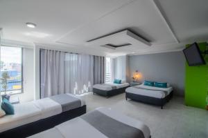 Una habitación de hotel con dos camas y un televisor de pantalla plana. en Hotel Elegant Suite, en Bogotá