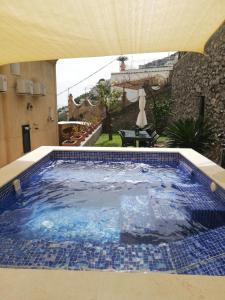 a swimming pool with blue tiles in a house at Villa Gea in Praiano