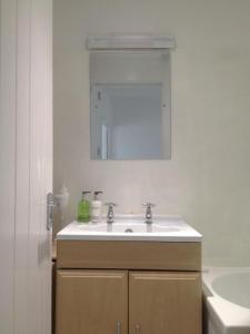 a white bathroom with a sink and a mirror at Ideally located cottage in Downalong St Ives in St Ives
