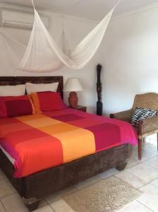 um quarto com uma cama colorida e uma cadeira em Tabonina Guesthouse em Livingstone