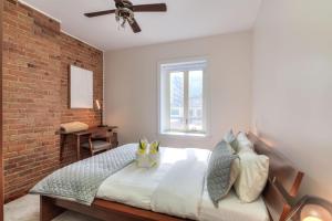 a bedroom with a bed with a brick wall at Fox Aparthotel Palais Des Congres VI in Montréal