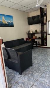 a living room with a couch and a tv at El Rinconcito in La Libertad