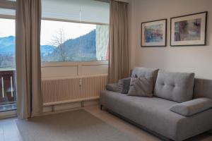 a living room with a couch and a large window at Apartment Seezeit in Strobl