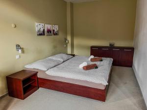 a bedroom with a bed with two teddy bears on it at Hotel Belaria Resort - wellness, bazén in Opava